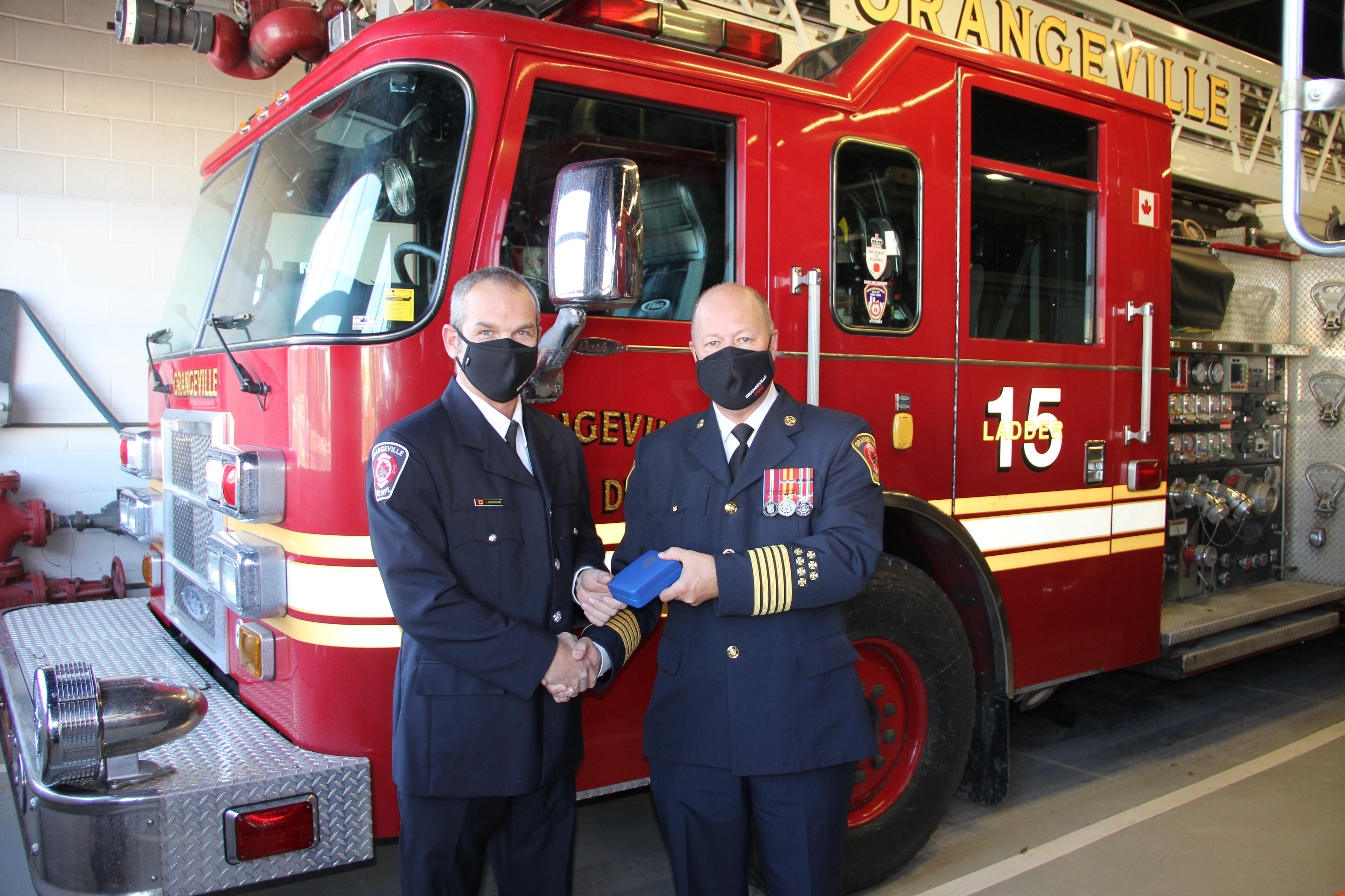 Shane Cunningham accepts the Federal Fire Services Exemplary Service Medal from Orangeville Fire Chief Ronald Morden